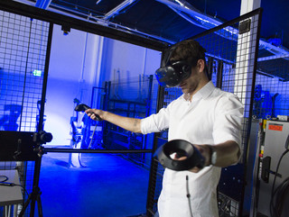 A staff member with a VR headset operating robots at the IDEAS campus