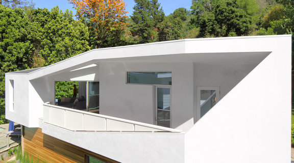 Image of an addition to a white angular house surrounded by trees in Beverly Hills, California.