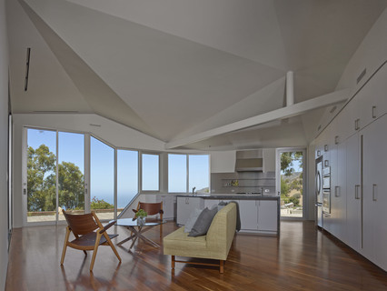 Image of the living space and kitchen inside the Vortex House, with an angular ceiling looking out across the Malibu Hills.