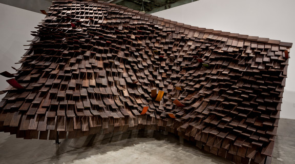 Images of Rawhide installation in the SCI-Arc Gallery. A scale model of the construction of the roof of a house with brown curled cedar shingles.