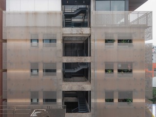 A photo of a white building facade with lots of square windows of different sizes