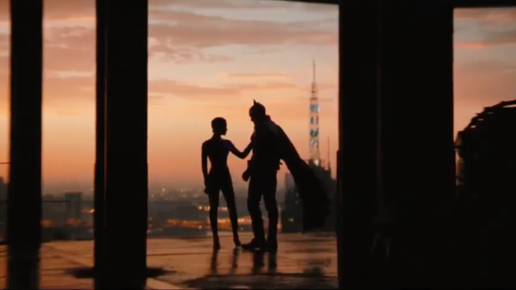 image of characters standing on the roof of a building with a sunset in the background