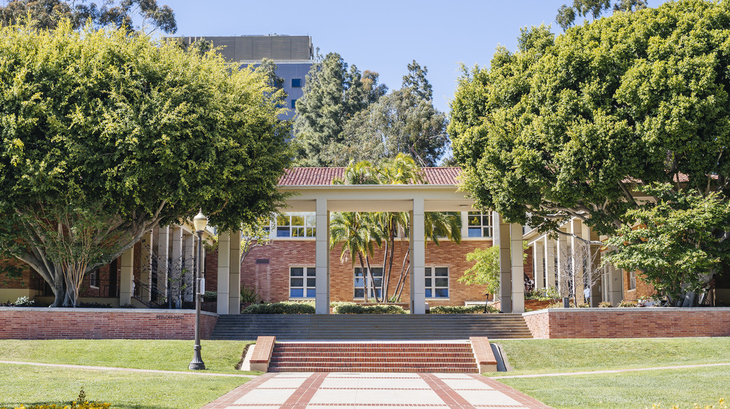 Image of a red brick building on the UCLA campus surrounded by trees