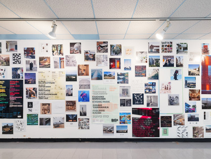 A photograph showing a series of architectural images, each on a square page, assembled across a wall like pixels