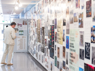 A photograph showing a series of architectural images, each on a square page, assembled across a wall like pixels