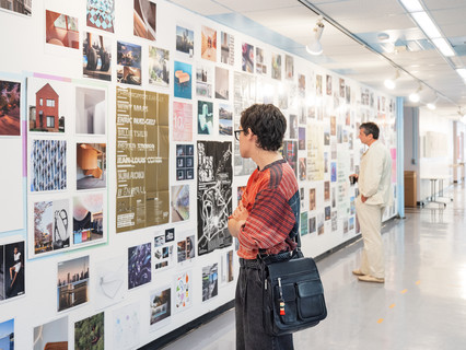 A photograph showing a series of architectural images, each on a square page, assembled across a wall like pixels