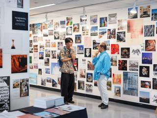 A photograph showing a series of architectural images, each on a square page, assembled across a wall like pixels