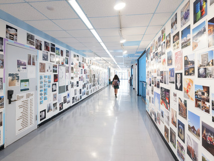 A photograph showing a series of architectural images, each on a square page, assembled across a wall like pixels