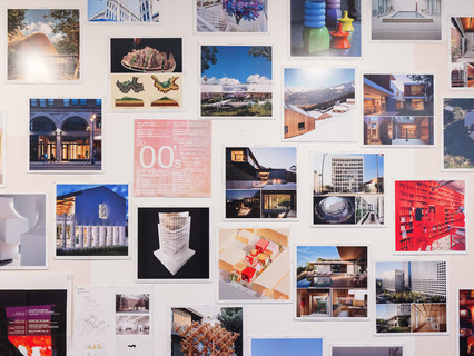 A photograph showing a series of architectural images, each on a square page, assembled across a wall like pixels