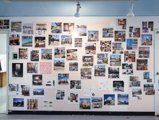A photograph showing a series of architectural images, each on a square page, assembled across a wall like pixels