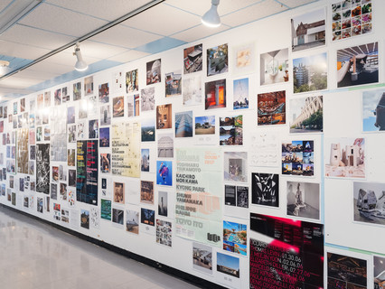 A photograph showing a series of architectural images, each on a square page, assembled across a wall like pixels