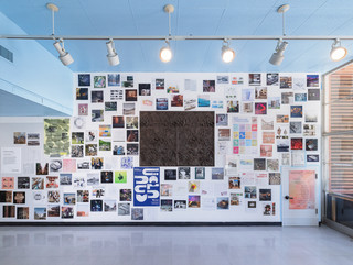 A photograph showing a series of architectural images, each on a square page, assembled across a wall like pixels