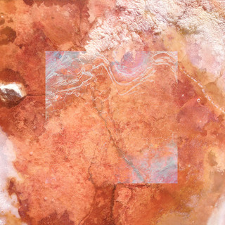 Aerial photograph of dried lake bed with varying degrees of red coloration and cloudiness.